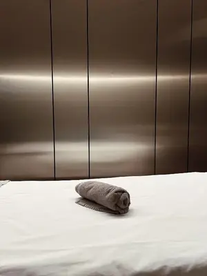 a towel laying on a bed in a room at Mana Sleep & Spa in Druskininkai
