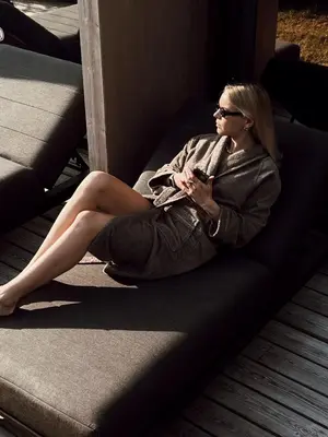 a woman sitting on a couch looking at her cell phone at Mana Sleep & Spa in Druskininkai