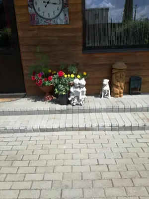 a clock on the side of a house with flowers at Viešnagė pas Valentiną in Sužionys