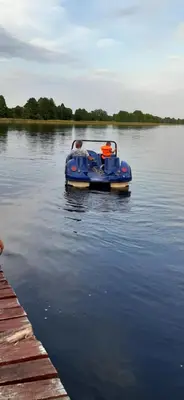 a blue boat in the water next to a dock at Viešnagė pas Valentiną in Sužionys