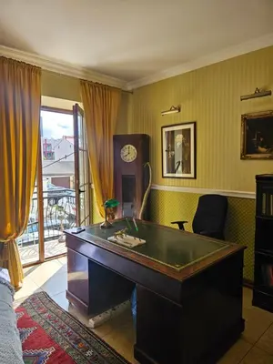 a desk in a room with a clock on the wall at Barrister's apartments with fireplace in Šiauliai