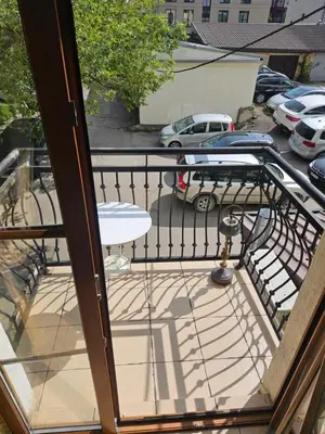 a balcony with a table and a parking lot at Barrister's apartments with fireplace in Šiauliai