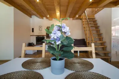 a vase with purple flowers on a table in a room at PRIVATE FREE SAUNA & 4 bedrooms Old Town Rooftop Apartment in Vilnius