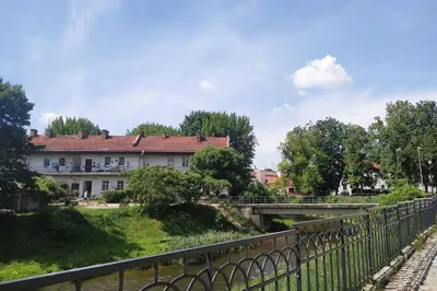 a bridge over a river in front of a building at PRIVATE FREE SAUNA & 4 bedrooms Old Town Rooftop Apartment in Vilnius