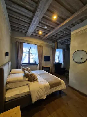 a bedroom with two beds and a desk and a mirror at Zyplių Dvaro Oficina Viešbutis in Lukšiai