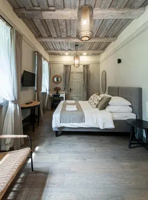 a bedroom with a large bed with a wooden ceiling at Zyplių Dvaro Oficina Viešbutis in Lukšiai