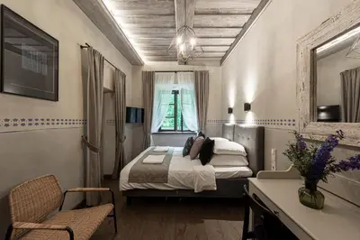 a bedroom with a bed and a table and a chair at Zyplių Dvaro Oficina Viešbutis in Lukšiai