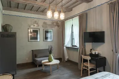 a room with a bed and a couch and a table at Zyplių Dvaro Oficina Viešbutis in Lukšiai