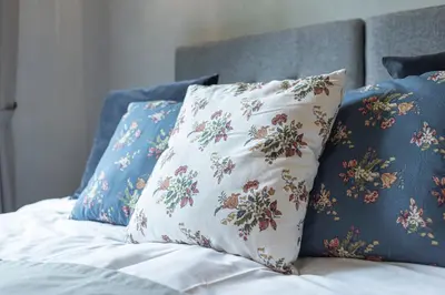 a bed with blue and white pillows on it at Zyplių Dvaro Oficina Viešbutis in Lukšiai