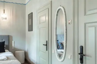 a bedroom with a white door and a mirror at Zyplių Dvaro Oficina Viešbutis in Lukšiai