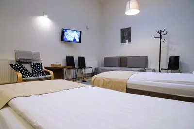 a hotel room with two beds and a tv on the wall at Jundula in Šakiai