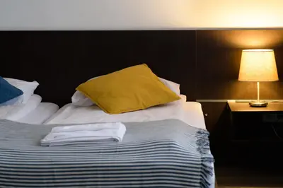 a bed with a yellow pillow on top of it at Jundula in Šakiai