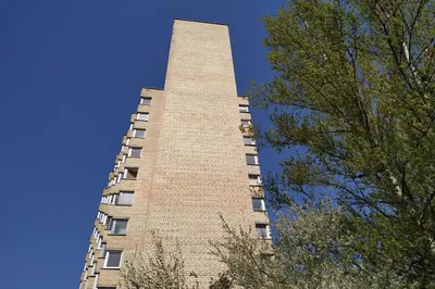 a tall brick building with trees in the foreground at 9th floor Amazing View Central Studio Apartment in Vilnius