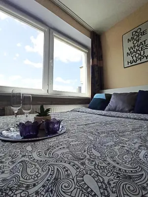 a bed with a tray of food and wine glasses on it at 9th floor Amazing View Central Studio Apartment in Vilnius