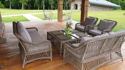 a patio with wicker chairs and a table at Stone house in Prapuntai