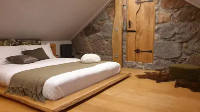 a bed in a room with a stone wall at Stone house in Prapuntai