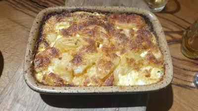 a casserole in a pan on a table at Stone house in Prapuntai