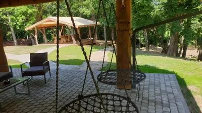 a porch with two chairs and a swing at Stone house in Prapuntai