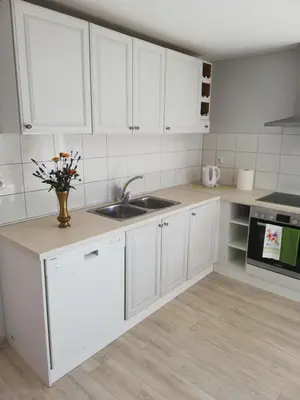 a kitchen with white cabinets and a sink at VĖJO16 in Biržai