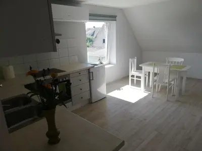 a kitchen and dining room with a table and a window at VĖJO16 in Biržai