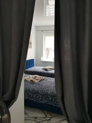 a bedroom with two beds and a window at Butas Senamiestyje Vytauto 7-4 in Rokiškis