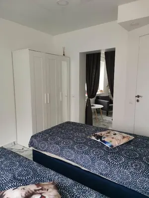 a bedroom with two beds and a living room at Butas Senamiestyje Vytauto 7-4 in Rokiškis