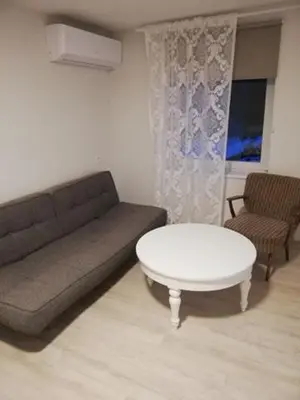 a living room with a couch and a table at Vėjo 16 in Biržai
