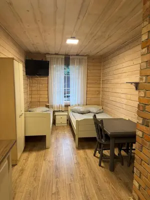 a room with two beds and a table in it at Atostogų būstas in Kurėnai