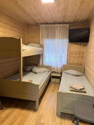 a bedroom with two bunk beds and a flat screen tv at Atostogų būstas in Kurėnai