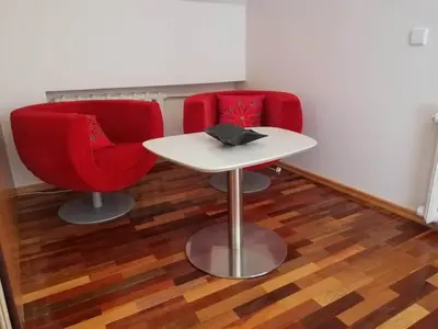 a table and two red chairs in a room at Ramus poilsis prie Širvintų marių in Širvintos