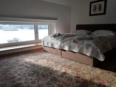 a bedroom with a bed and a window and a rug at Ramus poilsis prie Širvintų marių in Širvintos