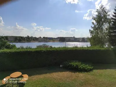 a view of a body of water behind a hedge at Ramus poilsis prie Širvintų marių in Širvintos