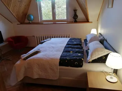 a bedroom with a bed and a desk with a lamp at Ramus poilsis prie Širvintų marių in Širvintos