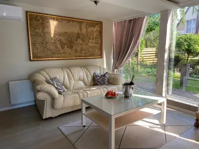a living room with a white couch and a table at Cosy and peaceful apartment in Kaunas
