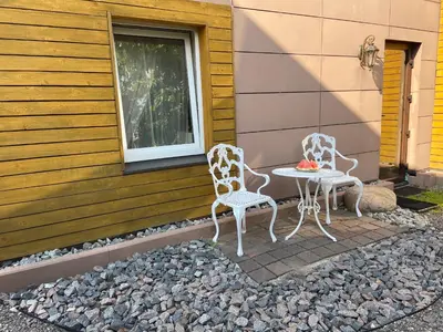 two chairs and a table on the side of a house at Cosy and peaceful apartment in Kaunas