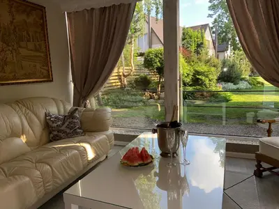 a living room with a couch and a glass table at Cosy and peaceful apartment in Kaunas