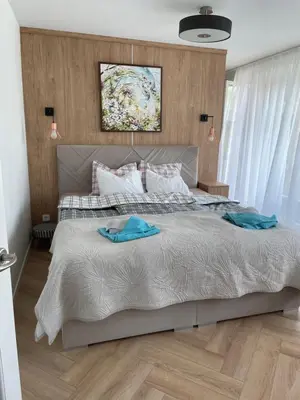 a bedroom with a large bed with two towels on it at Lake apartaments in Ignalina