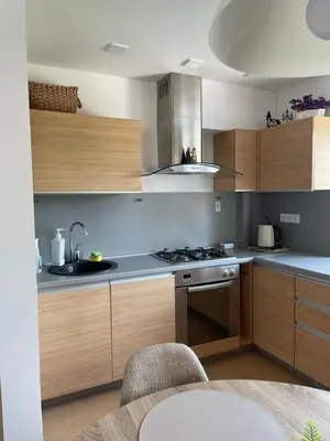 a kitchen with wooden cabinets and a stove top oven at Lake apartaments in Ignalina