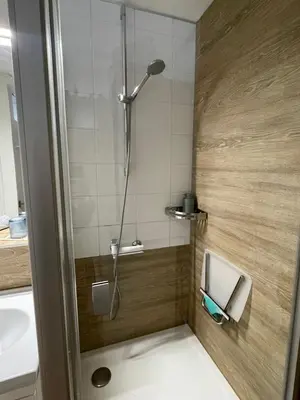 a shower stall in a bathroom with a sink at Lake apartaments in Ignalina