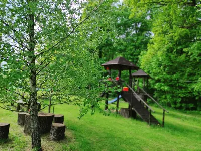 a playground with a slide in a park at Sodyba Basapėdė in Bijutiškis
