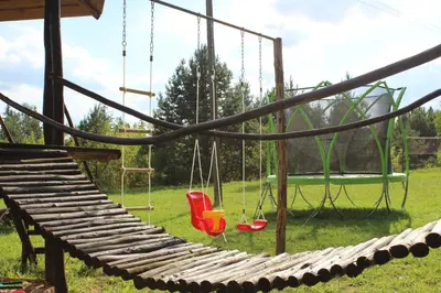 a swing set with two swings and a chair at Sodyba Basapėdė in Bijutiškis