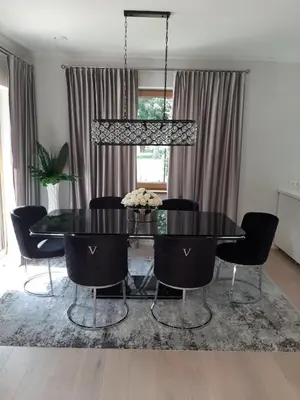 a dining room with a black table and chairs at Mazoji vila in Birštonas