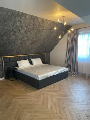 a bedroom with a bed and a wooden floor at Mazoji vila in Birštonas