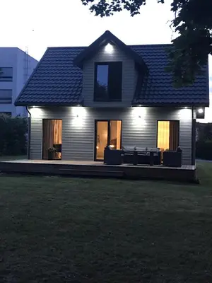 a house with lights on the front of it at Mazoji vila in Birštonas