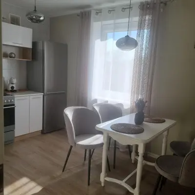 a kitchen with a white table and chairs and a window at Holiday Apartments 10 in Druskininkai
