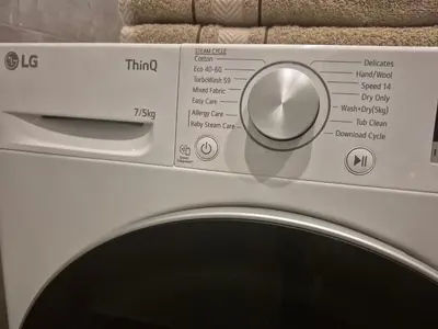 a close up of a washing machine with a knob at Holiday Apartments 10 in Druskininkai