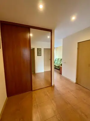 a room with a wooden door and a living room at Apartamentai Vytauto 16 in Druskininkai