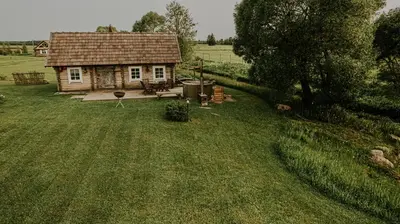 a small house in the middle of a field at Vienkiemio Oazė - Pasakų namelis in Galvokai