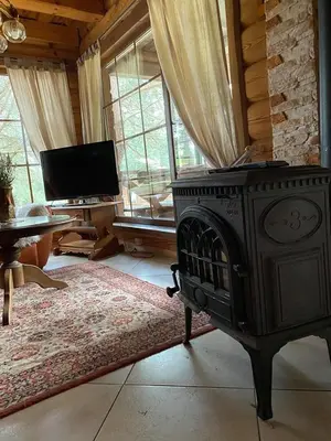 a living room with a stove and a tv at Šeimyninis namelis nr.1 in Kurėnai