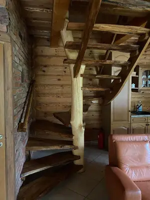 a wooden staircase in a room with a couch at Šeimyninis namelis nr.1 in Kurėnai